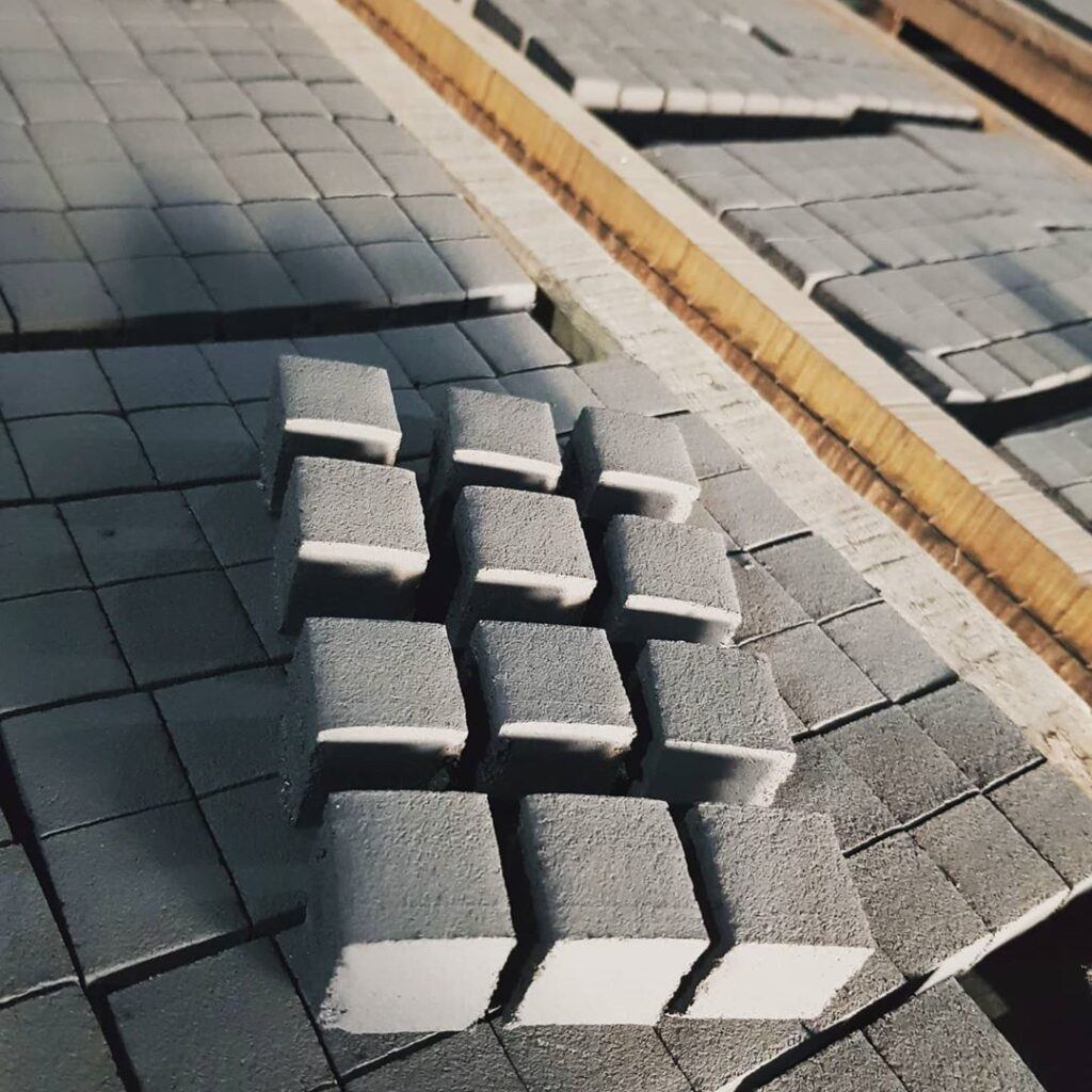 Freshly pressed coconut charcoal briquette cubes drying under the sun in Indonesia